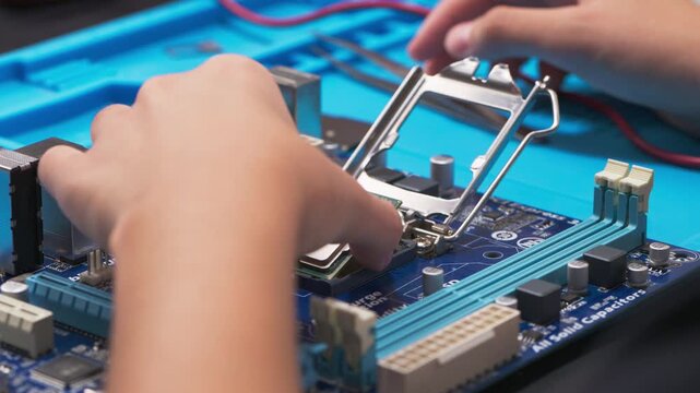 hand installing a central processing unit CPU microprocessor chip into computer motherboard socket as a conceptual metaphor for AI hardware technology computer engineering data 