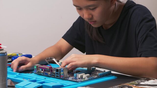 hand installing a central processing unit CPU microprocessor chip into computer motherboard socket as a conceptual metaphor for AI hardware technology computer engineering data 