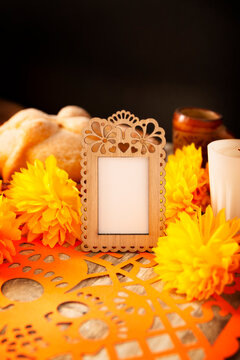 Day of the Dead altar mockup with blank photo frame, marigold flowers, pan de muerto, and candle. Dia de muertos celebration in Mexico.