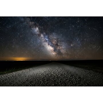 Milky way galaxy shining over dark rural gravel road