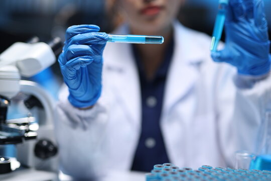 Scientist researching chemical liquid in test tube for analysis. Young scientist analyzing chemical liquid in test tube, conducting medical research and chemistry experiment in a laboratory.