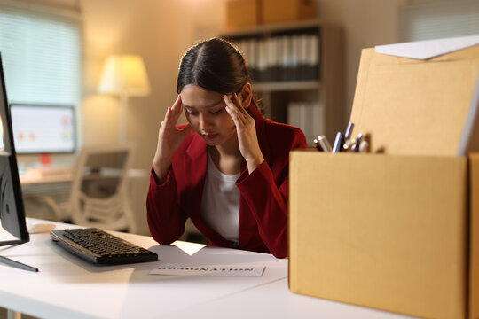 Stressed young woman planning resignation at night office.