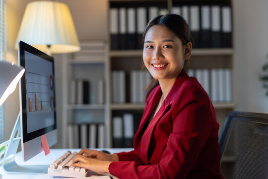 Asian businesswoman working late night at office desk.