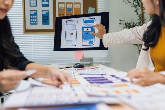 Professionals collaborating on interactive wireframe and user interface prototyping, optimizing user experience for digital product development.