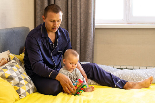Father Helping Baby Son Explore Colorful Activity Toy