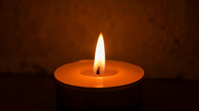 Single Burning Tea Light Candle Flickering in Dark Background 4K Generative AI