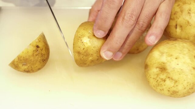 料理教室で包丁でジャガイモを切る男性シェフの様子