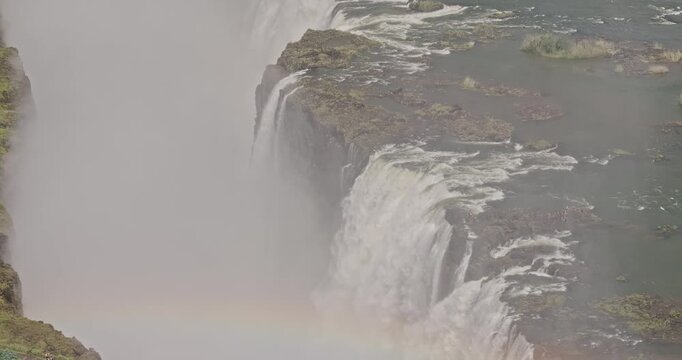 Victoria Falls Zimbabwe Aerial v4 zoomed birds eye view flyover the Devil's pool on the Zambezi River, with mist rising from the thundering waterfalls - Shot with 5k Camera - Jan 3rd 2024