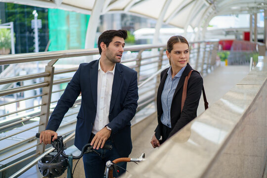 Caucasian business people walking with bicycle on city skywalk