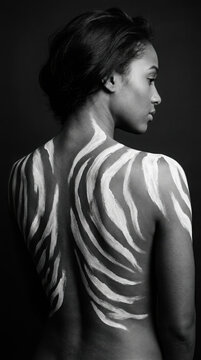 Woman with body paint strokes on her bare back in and studio generated using ai