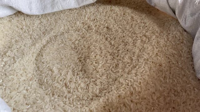 Close up of raw white rice grains inside a sack burlap