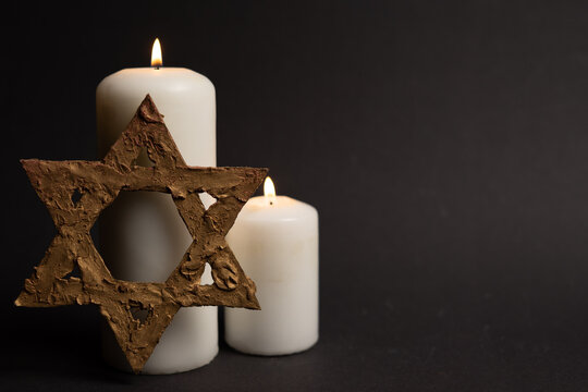 Star of David with two memorial candles on black background