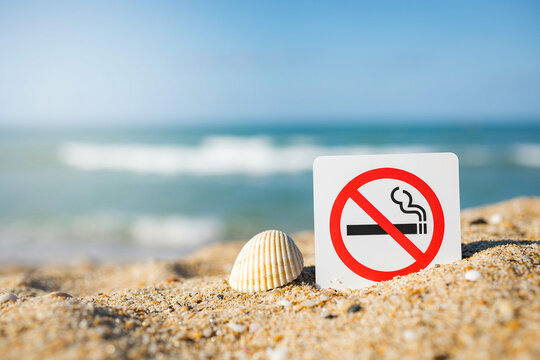 No smoking sign and seashell on sandy beach ocean background photo illustration