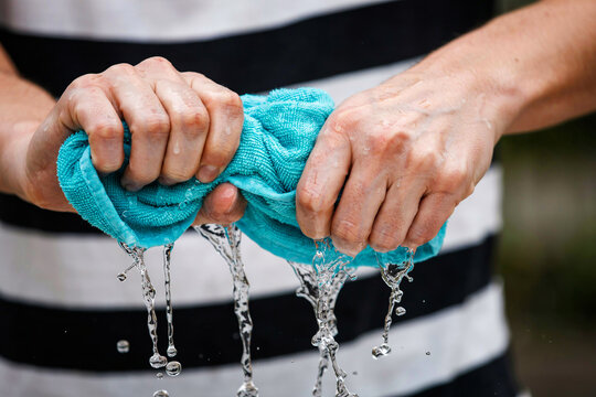 Hands wringing out wet blue microfiber cloth photo illustration