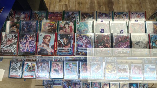 Chantilly, Virginia, USA &ndash; September 20, 2026: One Piece Card Game collectible cards are displayed on the glass shelves of a shop window. Rare cards featuring popular anime characters are encased