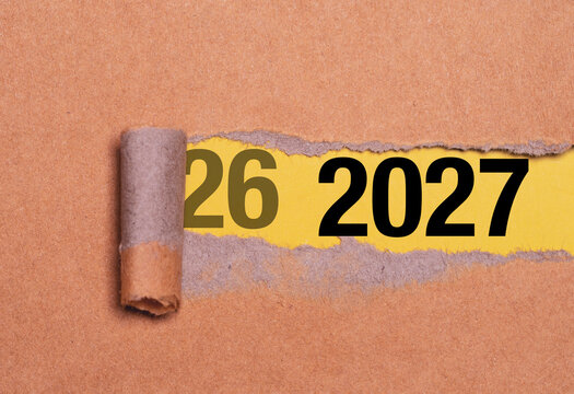 2027 New Year preparation concept with torn brown paper exposing numbers on a yellow background , it symbolize the transition from 2026 to 2027 to business beginning change and future planning.