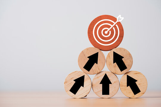 Business goal achievement concept with wooden arrows pointing toward a target bullseye symbolize collaboration teamwork planning and shared objectives to success and organizational growth.