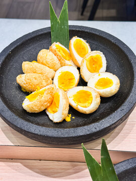 Golden Deep-Fried Hard-Boiled Egg Halves in Stone Bowl
