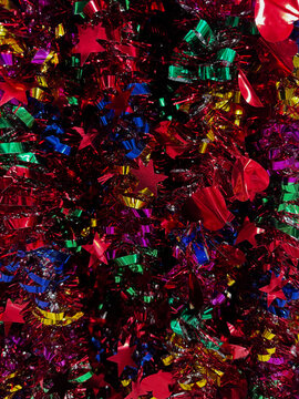 Full frame background of colorful shiny Christmas tinsel garland with star and heart shapes