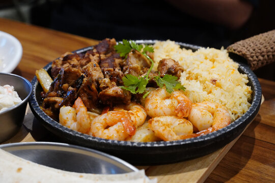 Sizzling mexican fajita platter with grilled shrimp, beef and yellow rice
