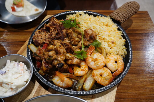 Sizzling mexican fajita platter with grilled shrimp, beef and yellow rice
