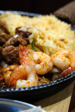 Macro shot of seasoned grilled shrimp on a sizzling mexican fajita platter