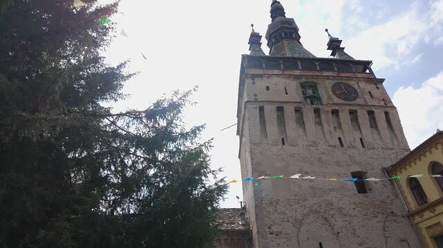 Sighisoara Clock Tower framed by trees in the historic medieval center of Transylvania Romania