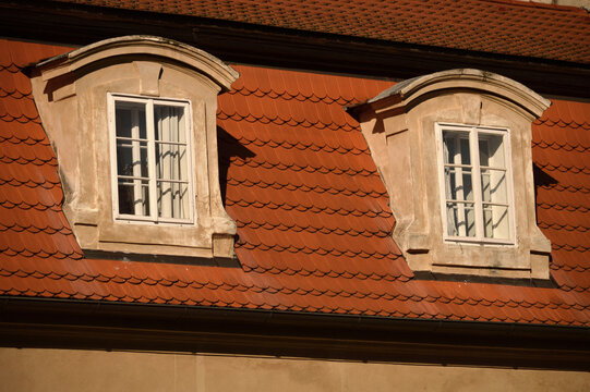 Historic building facade with red tiled roof and dormer windows