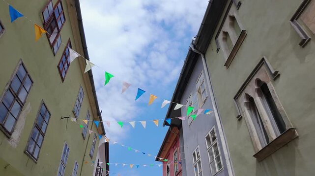 Colorful bunting above narrow medieval street in the historic center of Sighisoara Romania