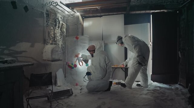 Technician harvests wall sample in frozen room using flashlight and pipette two investigators in protective suits mark specimen with red tags, test tubes on makeshift table, icy floor and cracked