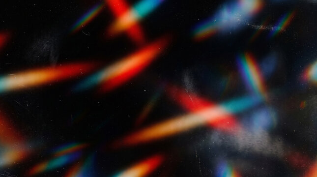 Colorful light patterns scatter across a dark surface during a nighttime event or activity in a space with low lighting