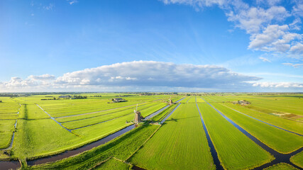 Fototapeta premium Aerial drone view of traditional windmills in the Netherlands. Panoramic view. Green fields and rural countryside landscape in the Dutch region.