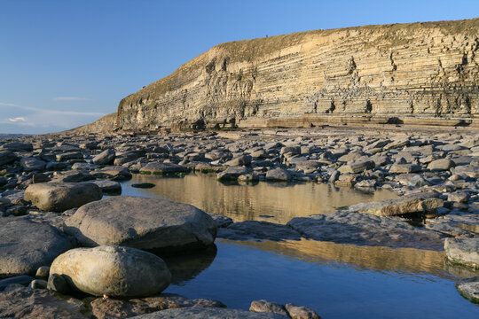 Rocky coastline and exposed rock pools at Southerndown Cliffs in Wales