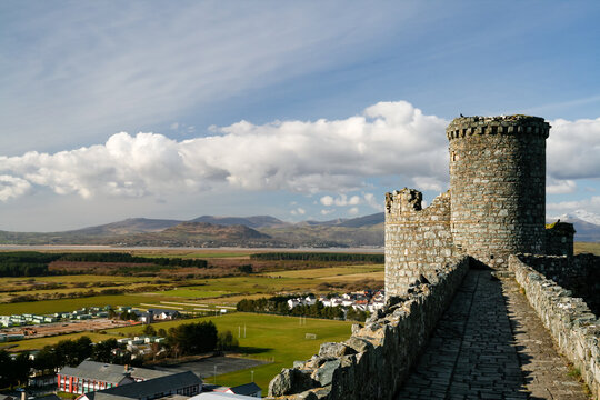 View from Harlech Castle stone ramparts looking towards rolling hills in Wales
