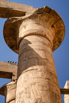 Massive stone column carved with hieroglyphics inside Karnak Temple in Luxor Egypt
