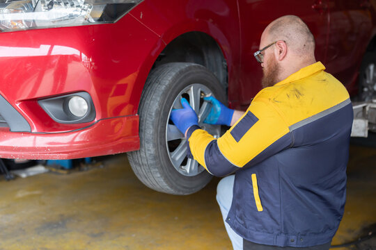 Mechanic changing wheel at the garage