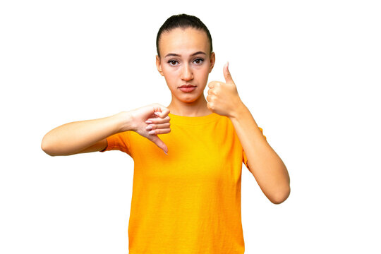 Young Arab woman over isolated background making good-bad sign. Undecided between yes or not