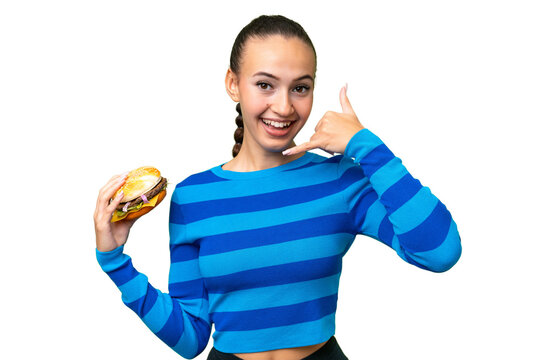 Young Arab woman holding a burger over isolated background making phone gesture. Call me back sign