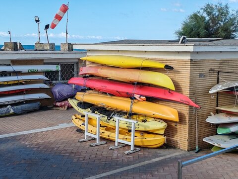 Ostia, Rome, Italy - September 9, 2026, neatly arranged red and yellow canoes and a synthetic fabric cone to measure the wind in a beach resort.