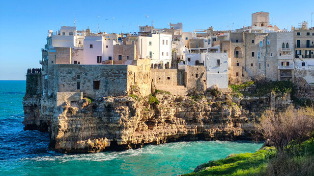 White houses on a rocky cliff in Polignano a Mare in Puglia, seen from Lama Monachile beach