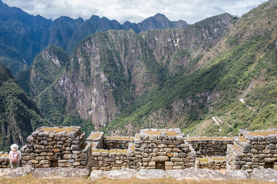 Traveler contemplating ancient inca ruins at machu picchu