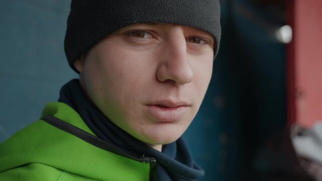 closeup of man listening carefully at game, portrait of focused man with scarf and beanie in dugout, male athlete attentively concentrating during tactical discussion on bench area