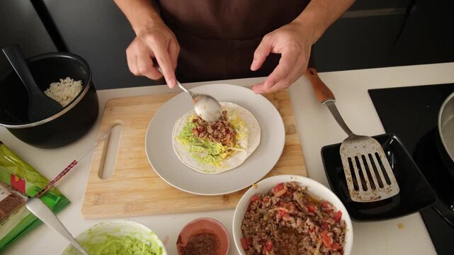 Male hands preparing and frying delicious homemade crunchwraps on an induction cooktop