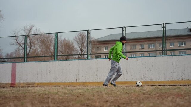 white man demonstrates speedy drills, male athlete in vibrant jacket executes rapid movements on grass, urban environment with male player practicing agility and speed drills outdoors