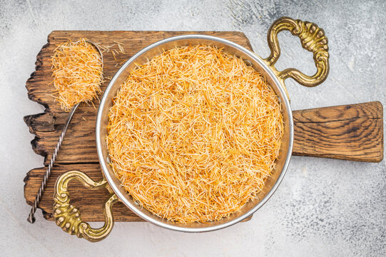 Raw kataifi pastry strands for kunafa and Middle Eastern desserts. Thin shredded phyllo texture on concrete background