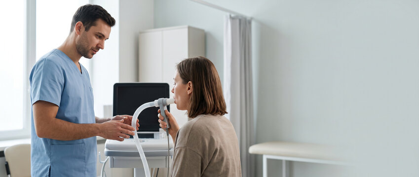 Adult patient completing lung function test with healthcare professional using spirometry equipment, representing respiratory health assessment, pulmonary testing and clinical patient care.