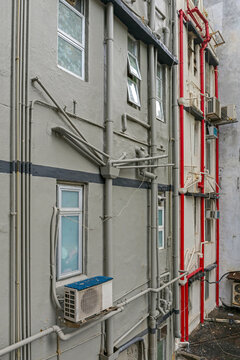 Plumbing Pipes and Air Conditioners Mounted on Exterior Wall of Building in Hong Kong