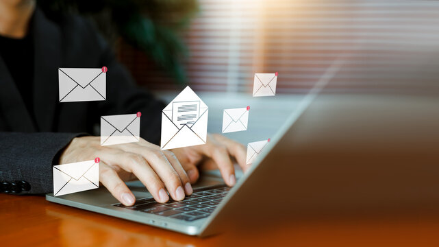 Businessman typing on laptop with virtual email envelopes and notification icons interface. Concept of email management, digital communication, message inbox, and corporate correspondence.