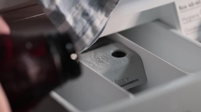 Stockholm, Sweden A hand pours laundry detergent into a washing machine drawer to wash clothes. 