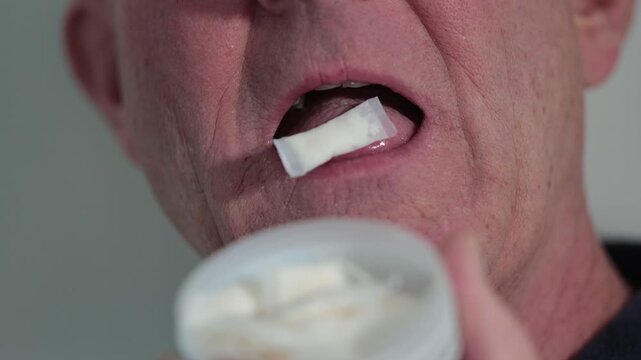 Stockholm, Sweden A man places a smokeless and tobacco-free nicotine pouch or snus on his tongue. 